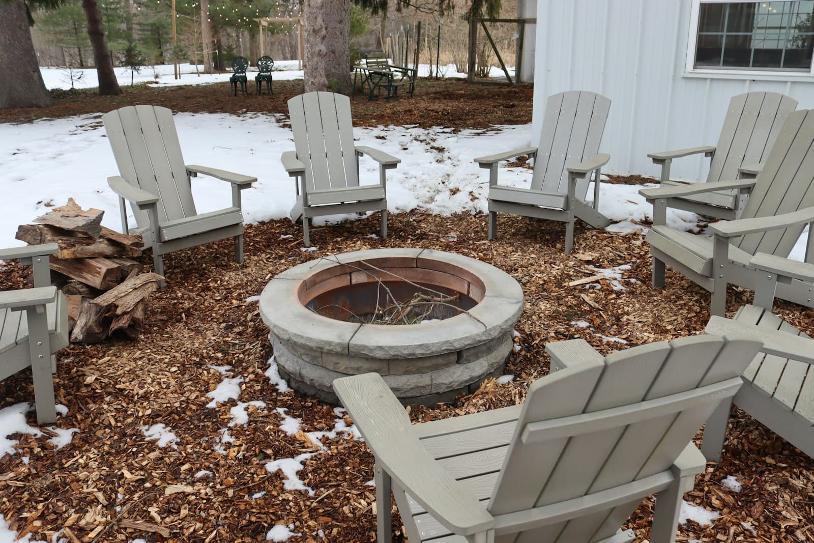 Adirondack chairs around a stone fire pit