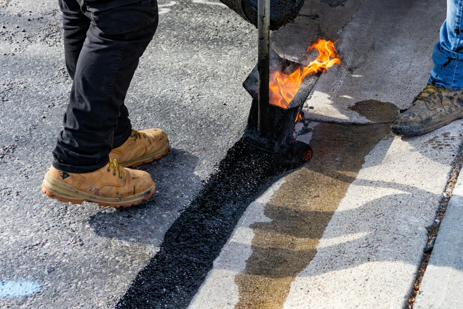 Crew applying hot asphalt during a paving job
