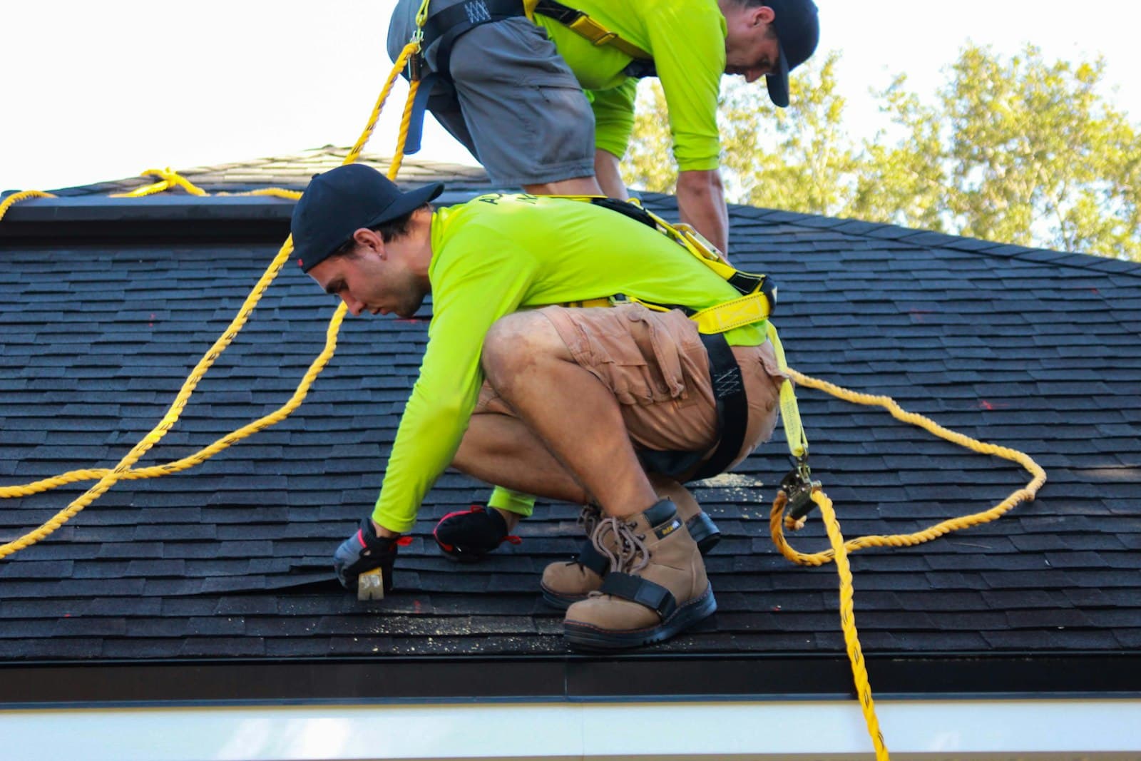 Roofers installing shingles on a house